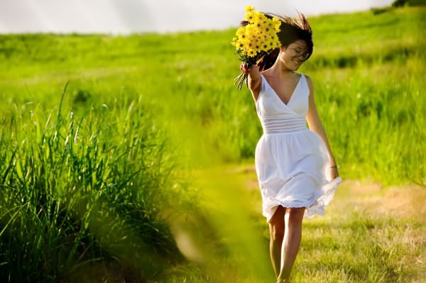 Девушка в поле с цветами и хорошим настроением